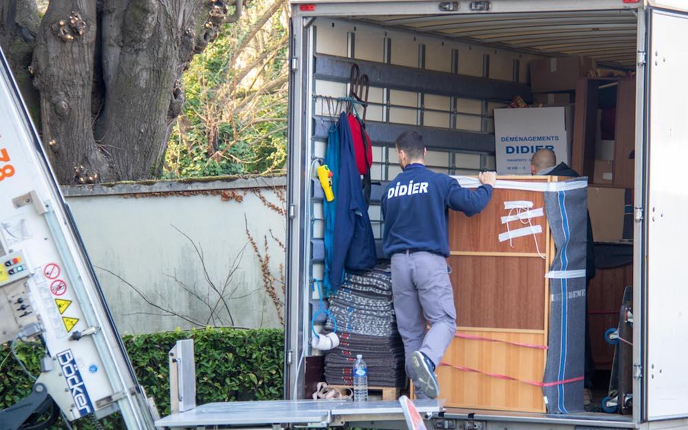 Déménageur chargeant un meuble dans la remorque monte meubles